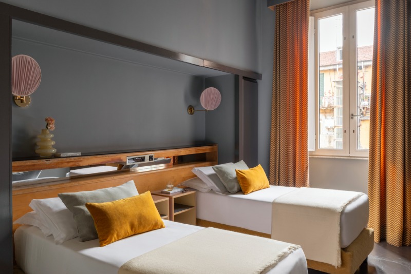 Second bedroom of the connecting Family Room with twin beds, pink wall lamps and bright windows - Hotel Milani, BZAR hotels in Rome
