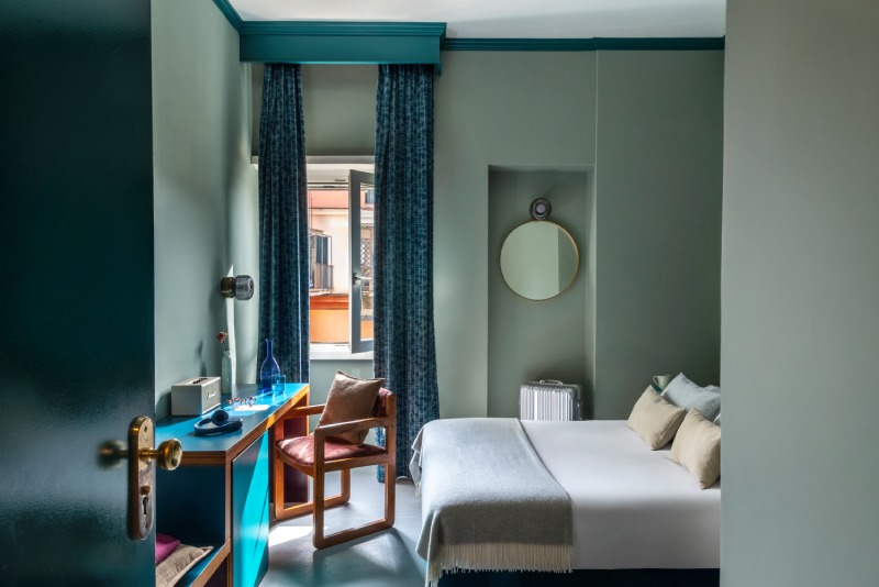 Small double room with a modern blue desk and a street view from the window - Hotel Milani, BZAR hotels in Rome