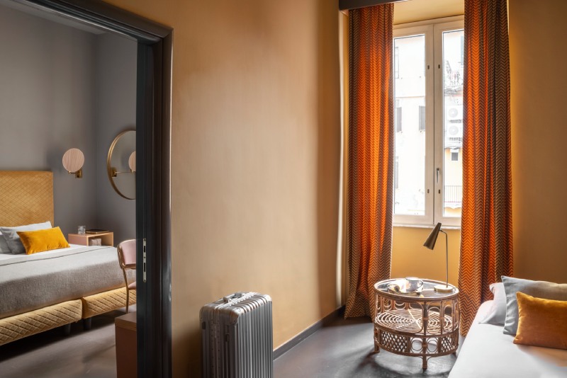 Triple room entrance with dark brown lacquered doors, bright red built-in wardrobe detail, and desk niche - Hotel Milani, BZAR hotels in Rome